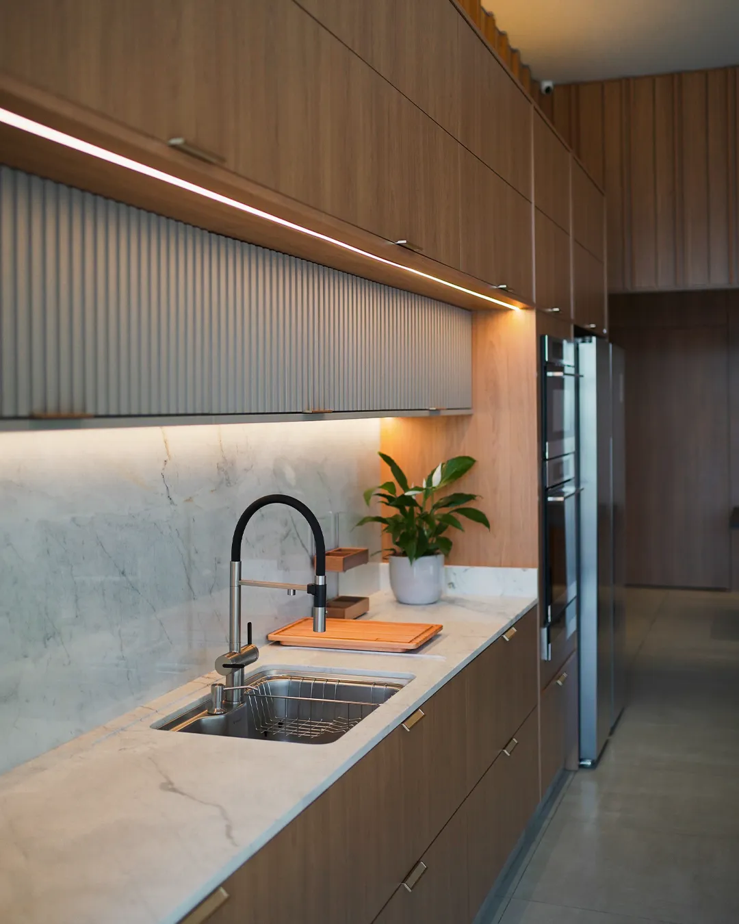 Detalhe de cozinha planejada com bancada em mármore