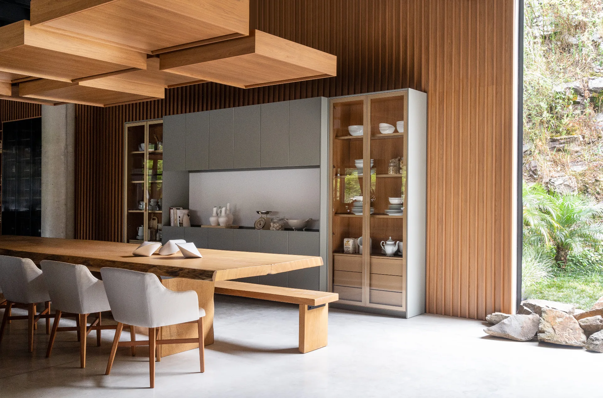 Cozinha planejada de alto padrão com marcenaria em madeira nobre, ilha em mármore e iluminação quente